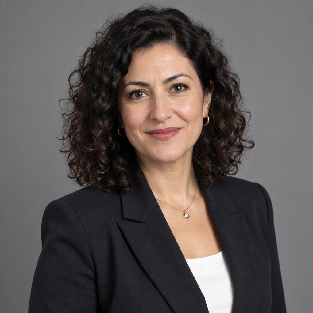 Turkish woman in her 40s with curly hair in a blazer